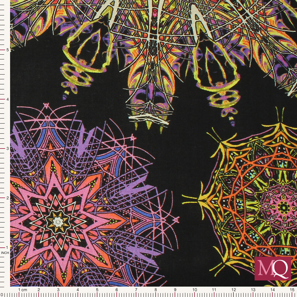 Cotton quilting fabric with kaleidoscope design in bright yellows, reds, pinks and blues on black background