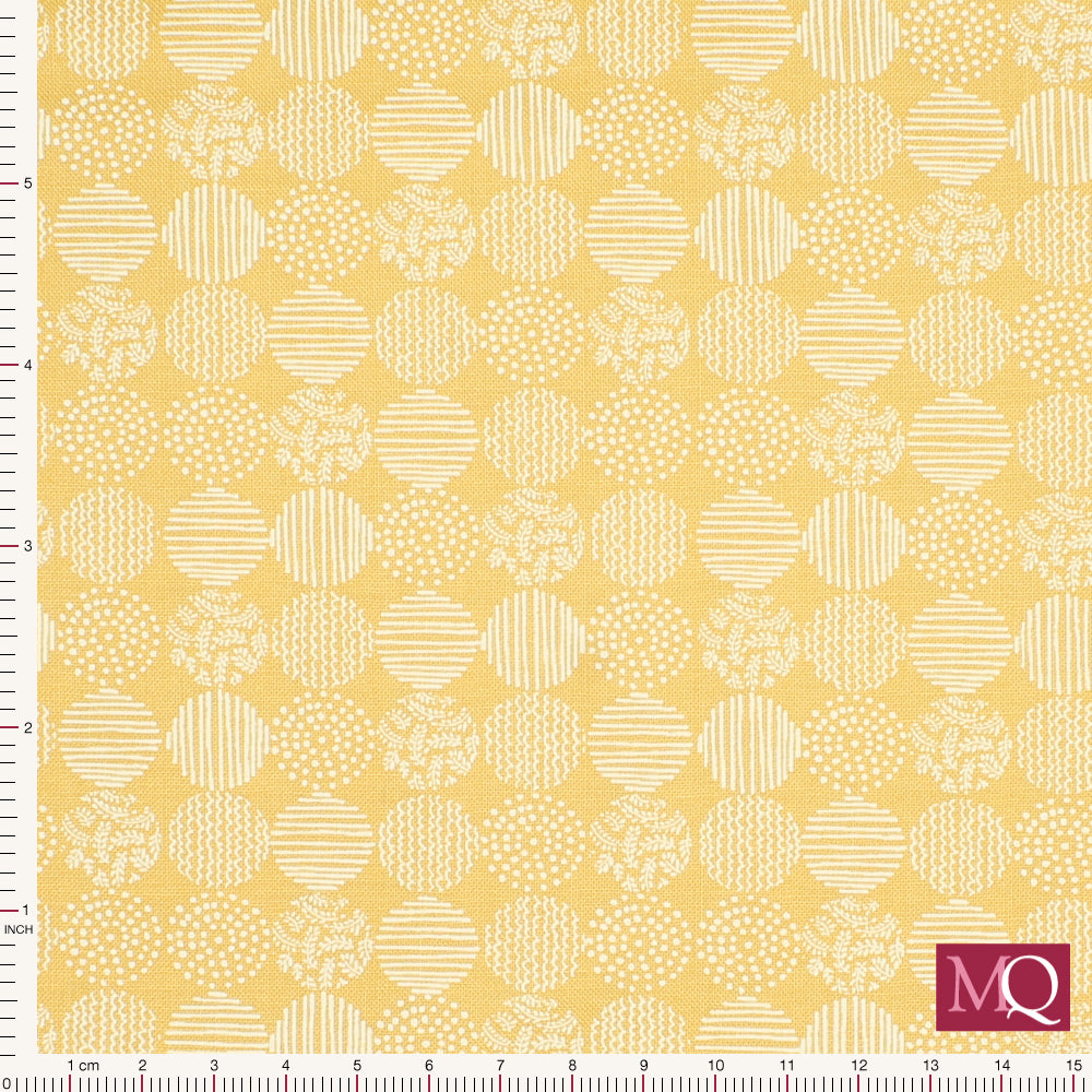Cotton quilting fabric with subtle patterned dots on mustard yellow background