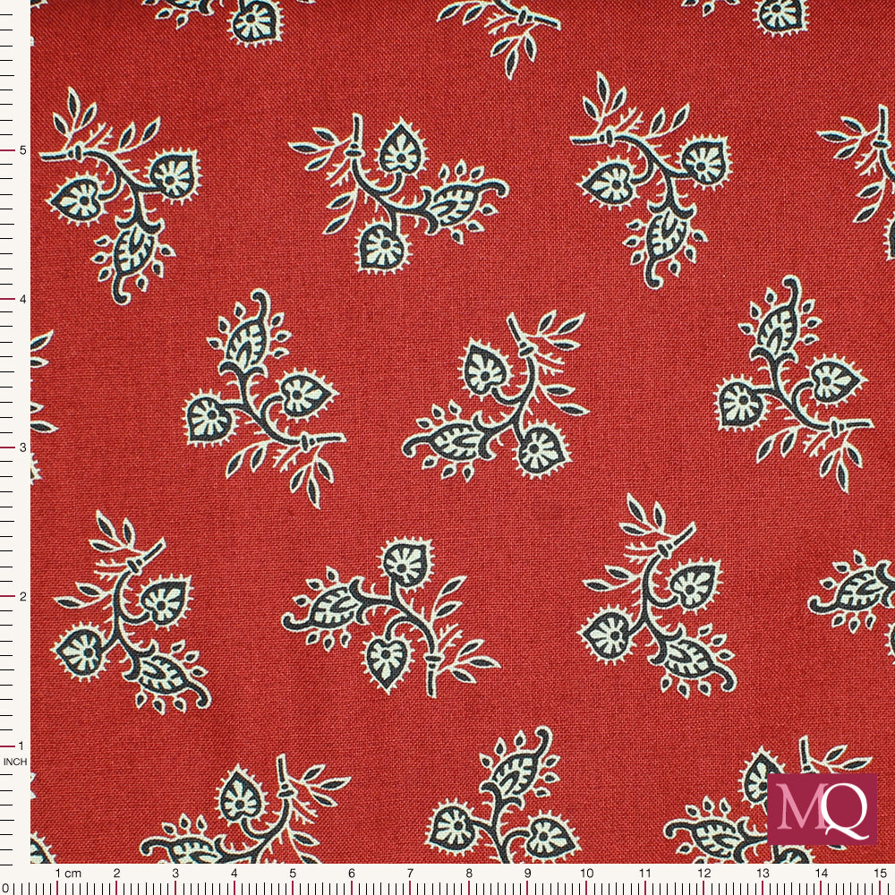 Cotton quilting fabric with simple floral paisley design in black and white tumbling over a rich red background